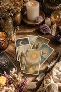 Cartas de tarot sobre mesa de madera con vela y cuarzos